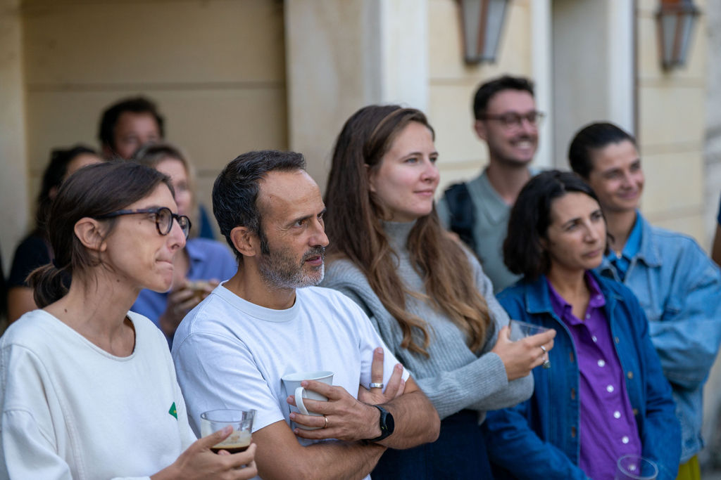 Un groupe de membres écoute une présentation en plein air