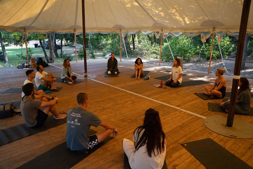 Séance de yoga collective sous la tente